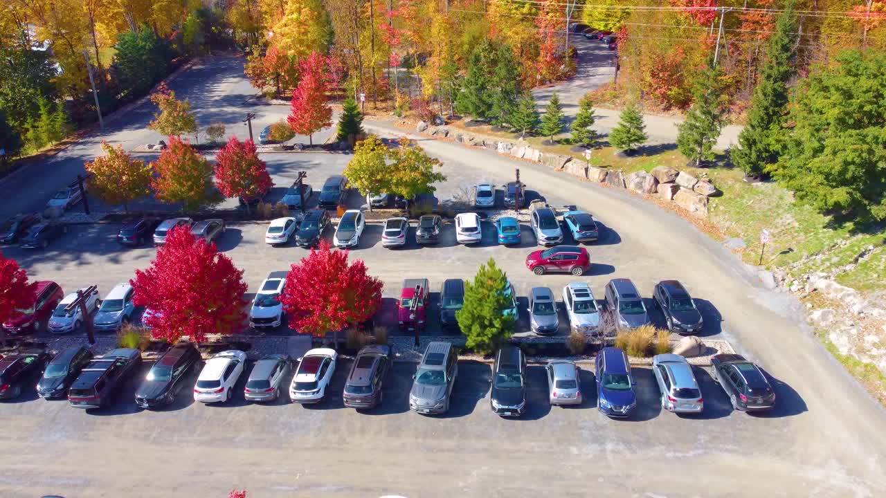 Aerial: parking with cars in a typical Canadian town with autumn colors in region of Estrie, Quebec, Canada