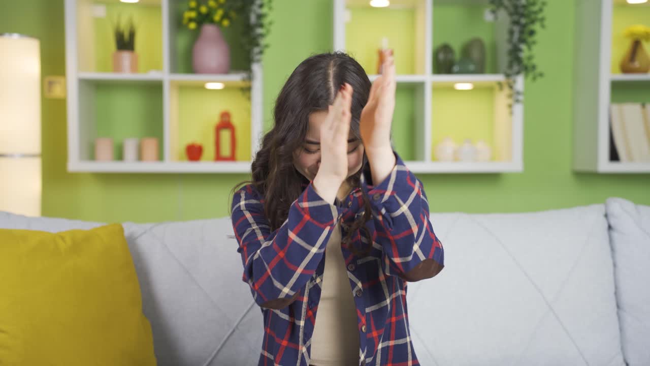 젊은 아시아 여성이 흥분하고 자랑스럽게 박수를 치고 있습니다.