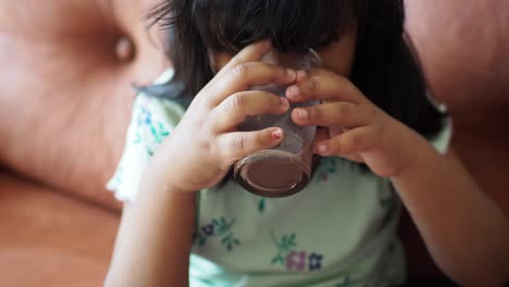 una niña bebiendo leche de chocolate