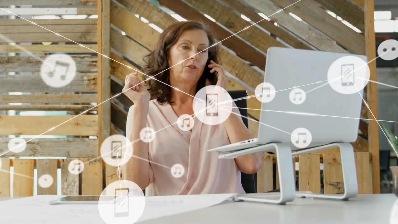 Animazione di una rete di icone digitali su una donna caucasica che parla al telefono in ufficio