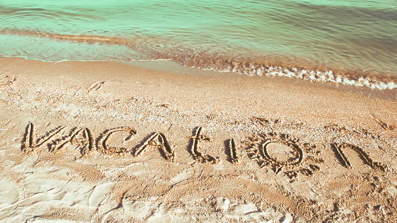 The inscription Vacation on sand. Inscription on sand