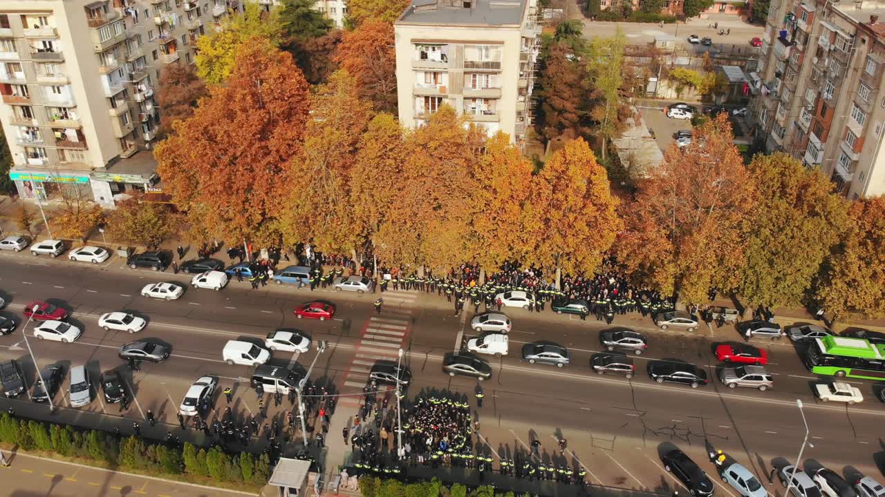 tbilisi, georgia - 10 de noviembre de 2021: vista aérea tropas policiales arrestan a un manifestante agresivo en la calle en la protesta anti-gobierno en la calle de saburtalo por la oficina de seguridad estatal
