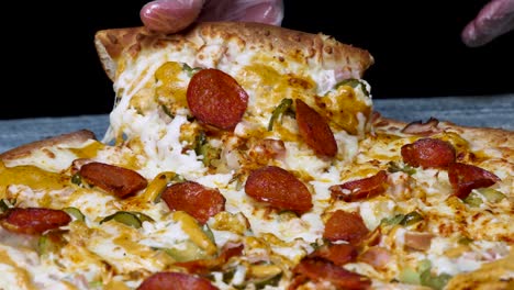 mano sosteniendo una rebanada de deliciosa pizza cargada