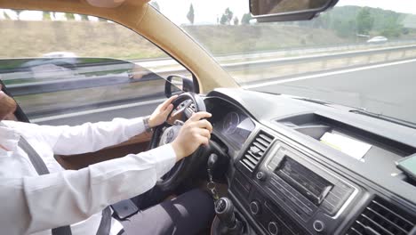 a young man in sunglasses is driving a car.