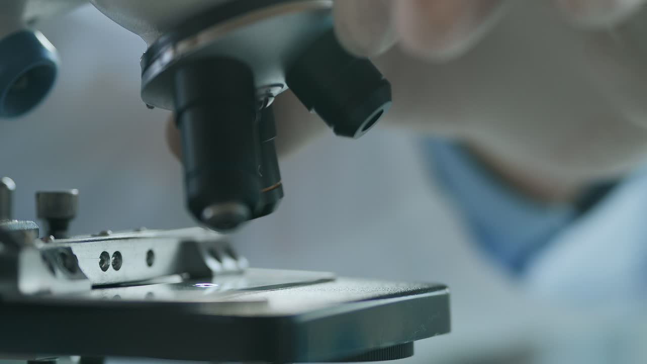 Close-up shot of microscope at laboratory. Researchers working in lab with microscope. examining of test sample under the microscope in laboratory. High quality 4k footage
