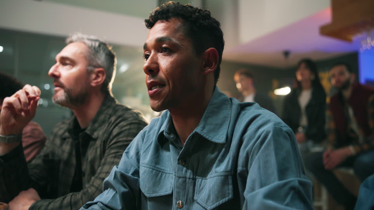 Excited group of people watching sports at a bar