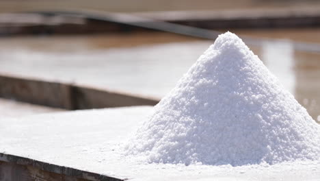 Pile-Of-Natural-Salt-Drying-On-Wooden-Table-At-Rio-Maior-Saltpans-In-Rio-Maior,-Portugal