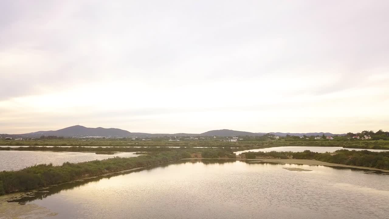 muñeca aérea en vuelo sobre las salinas y la reserva natural de fuseta portugal al atardecer