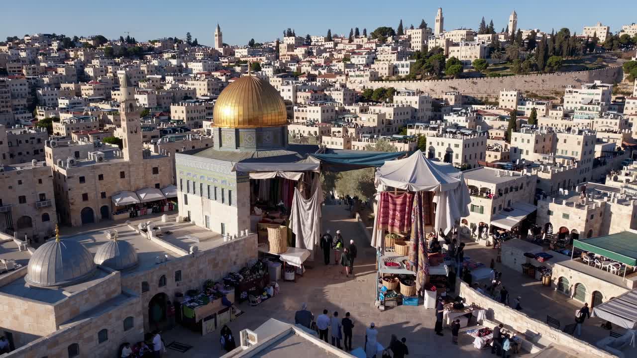Aerial video view of a historic cityscape with a golden dome, showcasing a vibrant market