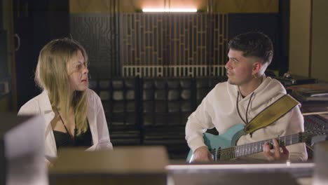 dos músicos trabajando en un estudio de música mientras graban una nueva canción