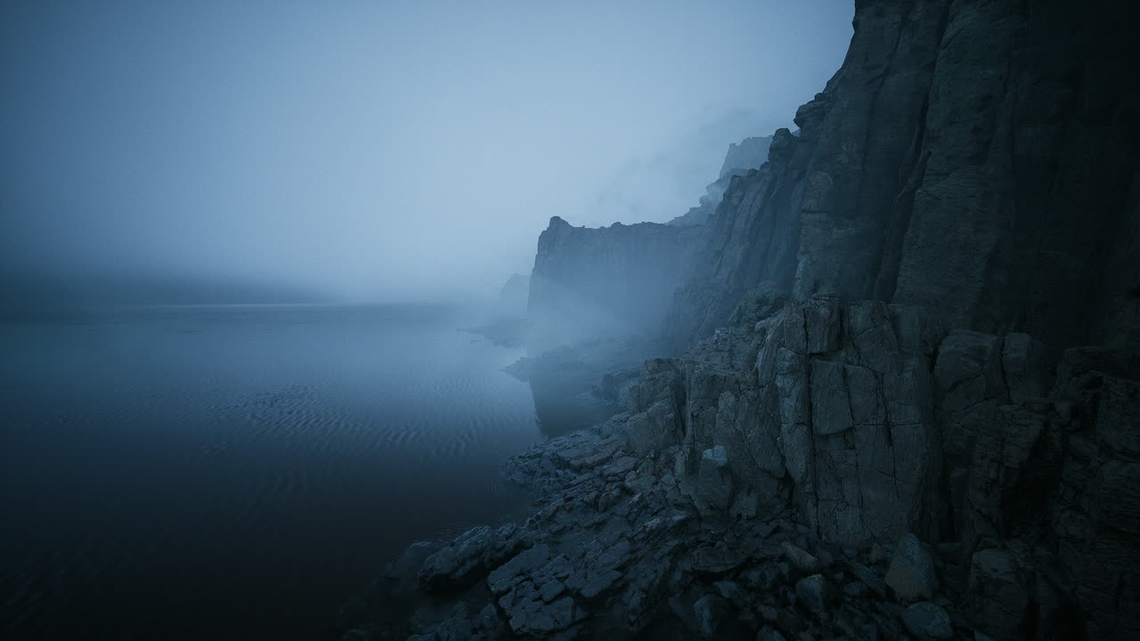 Mysterious fog envelops rocky coastline during twilight hour
