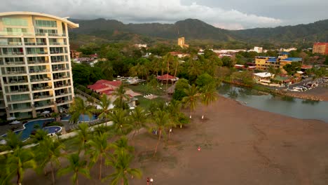 Jaco-Beach-Costa-Rica-Mit-Hotelpalmen-Und-Strand-Mit-Auf-Sand-Geparkten-Autos