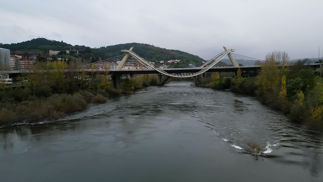 Static view of Millennium Bridge Mi&ntilde;o River in Ourense, Galicia, Spain as seagull soars in sky