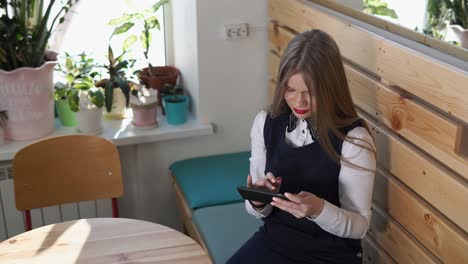 joven usando un teléfono inteligente en un café