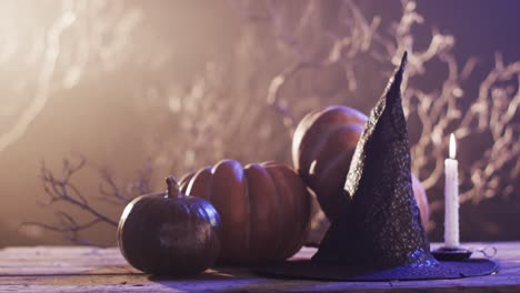 video of halloween pumpkins, hat, candle and copy space on brown background