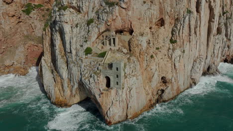 Fantastische-Luftaufnahme-Des-Historischen-Bergbauhafens-Von-Porto-Flavia-Im-Süden-Sardiniens-Und-Der-Wellen,-Die-An-Der-Klippe-Brechen