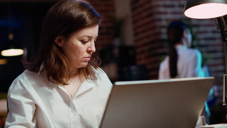 Businesswoman-researching-key-data-for-company-project-on-laptop