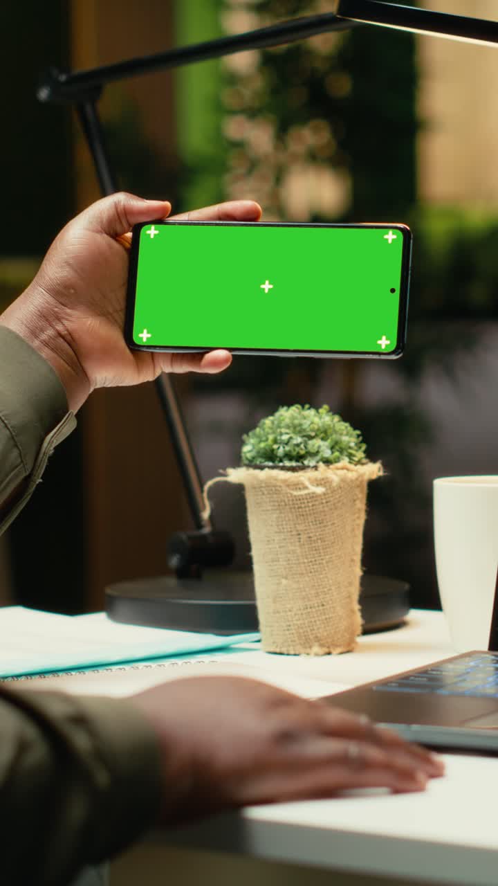 Vertical Video Green screen on smartphone at desk with black business person