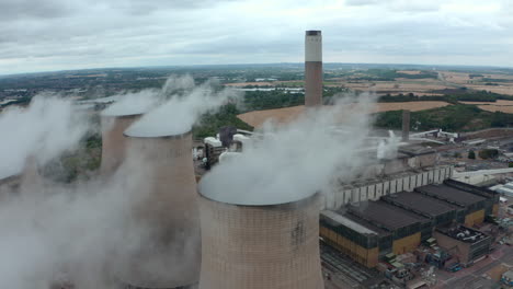 close up circling drone shot of large power station cooling towers and chimney