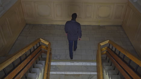 man walking upstairs in an old building