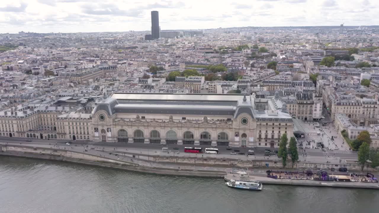 A stunning aerial drone video flies closely above the Musée d'Orsay with sweeping views of the Tuileries Garden and the Seine River in Paris