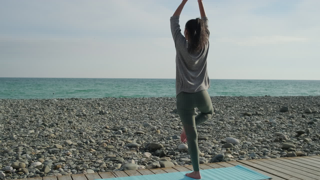 해변에서 요가를 연습하는 여자