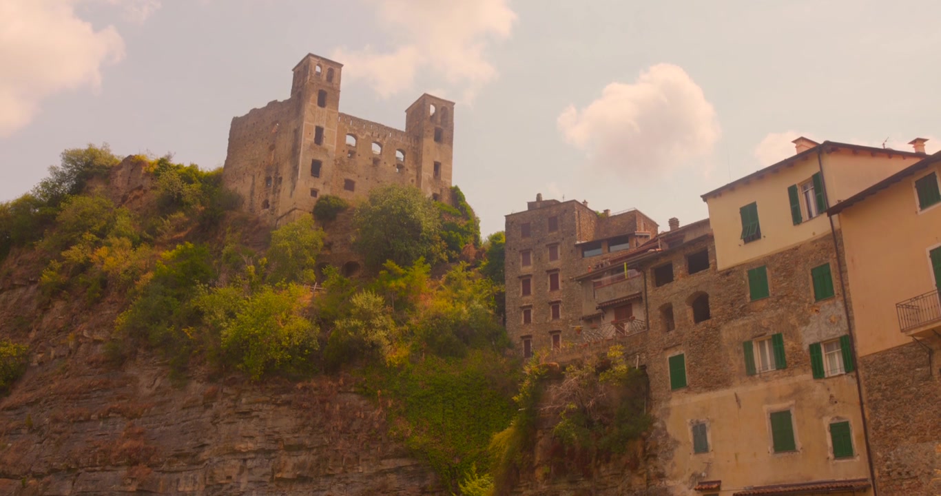 Lo storico Castello Doria si erge sopra il borgo medievale collinare di Dolceacqua in Liguria, Italia, circondato dalla vegetazione mediterranea