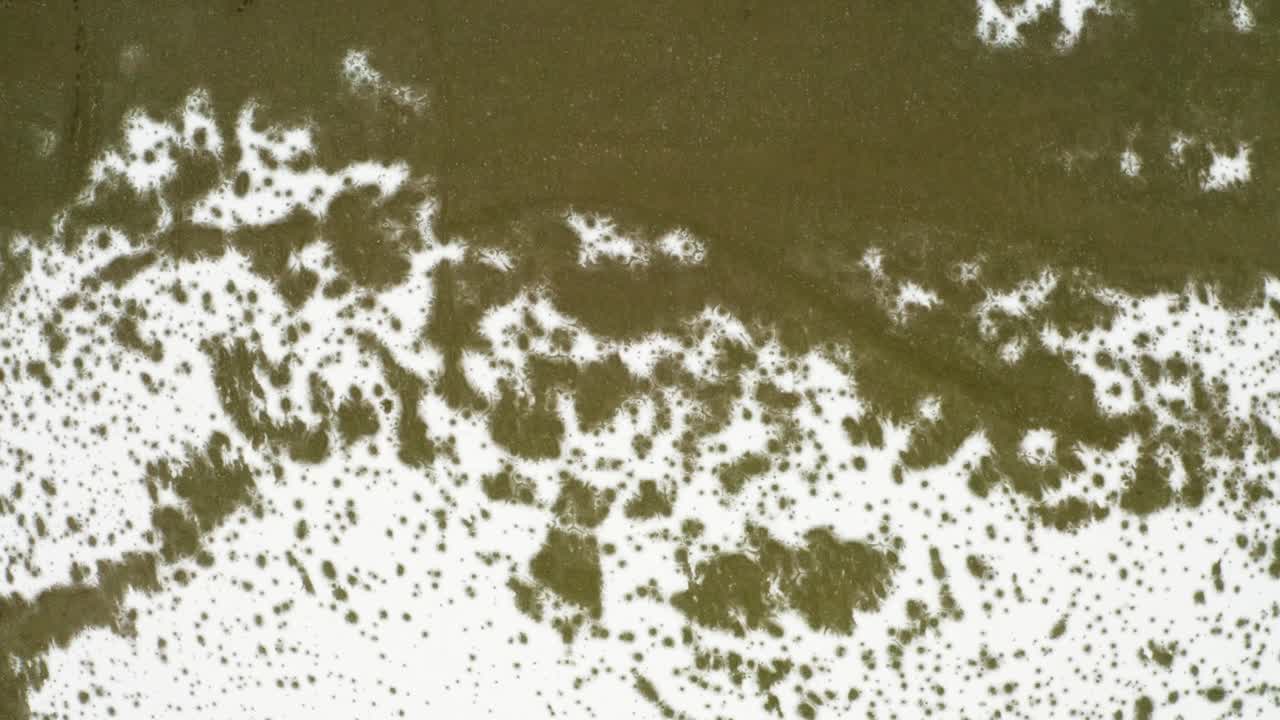 Stunning top-down drone footage showcasing icy formations and sediment textures of Svínafellsjökull Glacier.