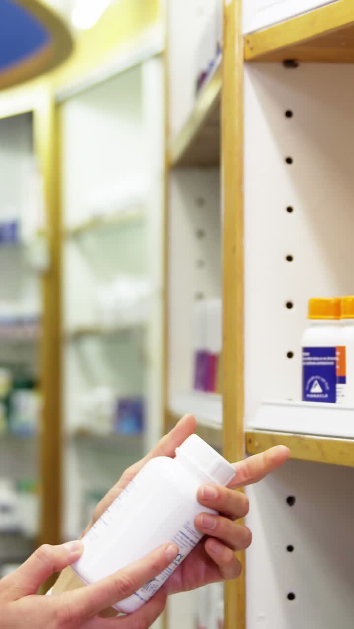 Pharmacist checking a bottle of drug