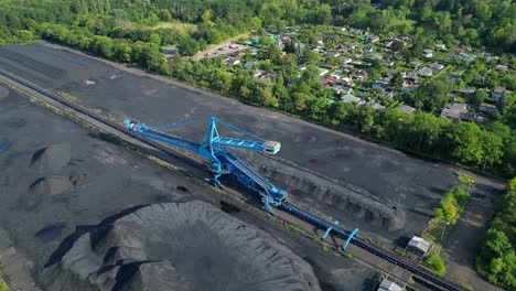spreader reclaiming coal excavator at a coal terminal near residential area. best aerial view flight drone shot footage from above