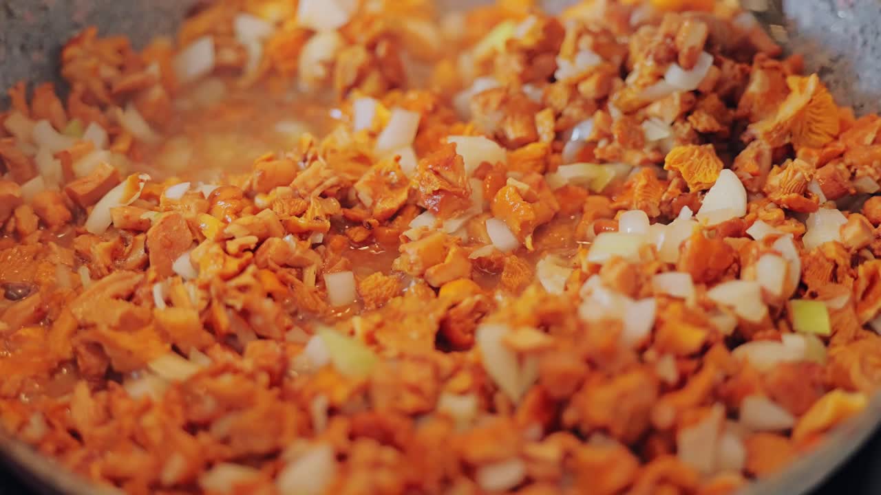 Golden mushrooms sizzling in pan with chopped onions creating rich aroma
