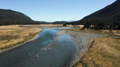 Aerial-drone-fly-by-footage-of-fly-fishing-at-Eglinton-River,-New-Zealand