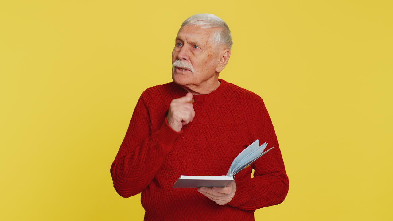 Thoughtful senior man making notes writing down thoughts with pen into notepad notebook good idea