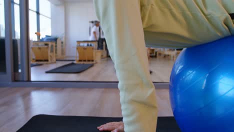 mujer mayor haciendo ejercicio en la pelota de ejercicio 4k