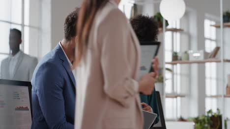 mujer de negocios de raza mixta líder de equipo de lluvia de ideas con un colega de negocios usando una computadora portátil mostrando ideas apuntando a la pantalla trabajando juntos en la oficina