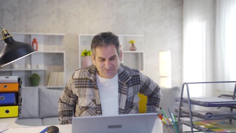 Fröhlicher-Und-Glücklicher-Home-Office-Mitarbeiter-Schaut-Auf-Laptop-Und-Freut-Sich.