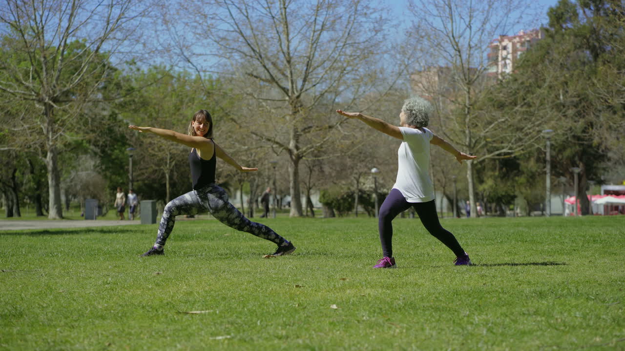 una mujer mayor sonriente practicando yoga con el entrenador.