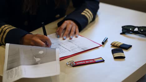 Unrecognizable-female-pilot-preparing-flight-documentation-on-a-tablet