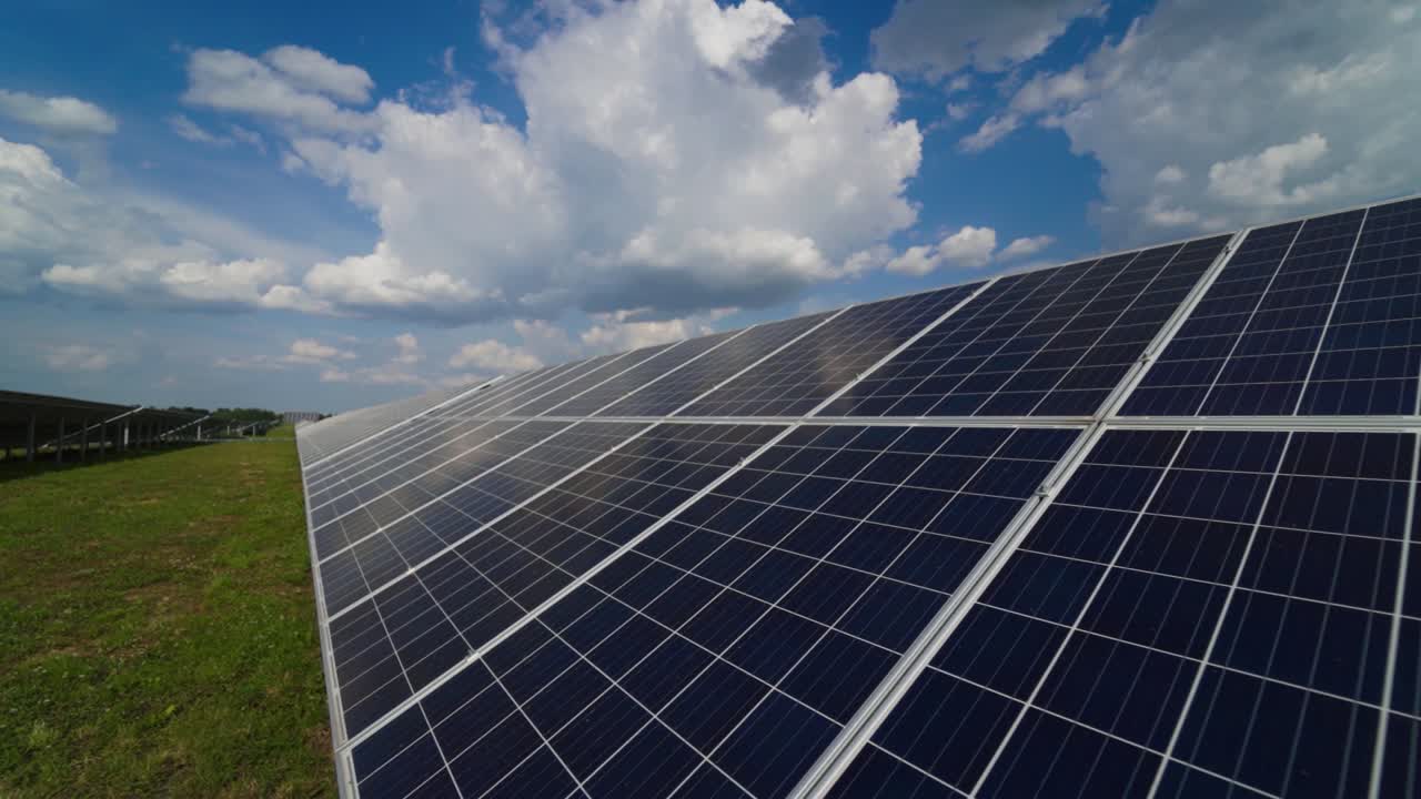 Solar panels on a modern electrical station. The clouds are reflected on the surface of the solar panels. Alternative clean electricity.