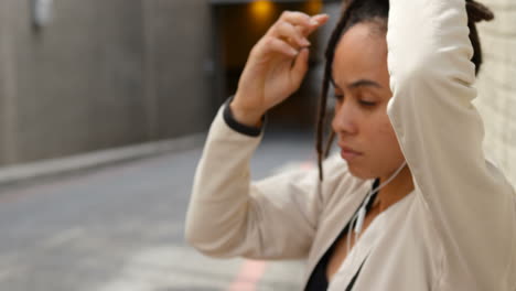 front view of young african american woman tying her updo in the city 4k