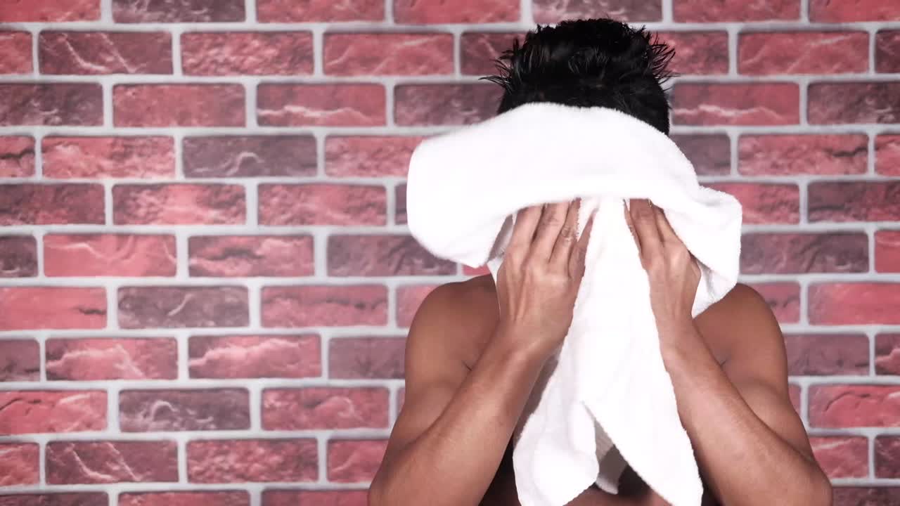hombre secándose el cabello después de la ducha