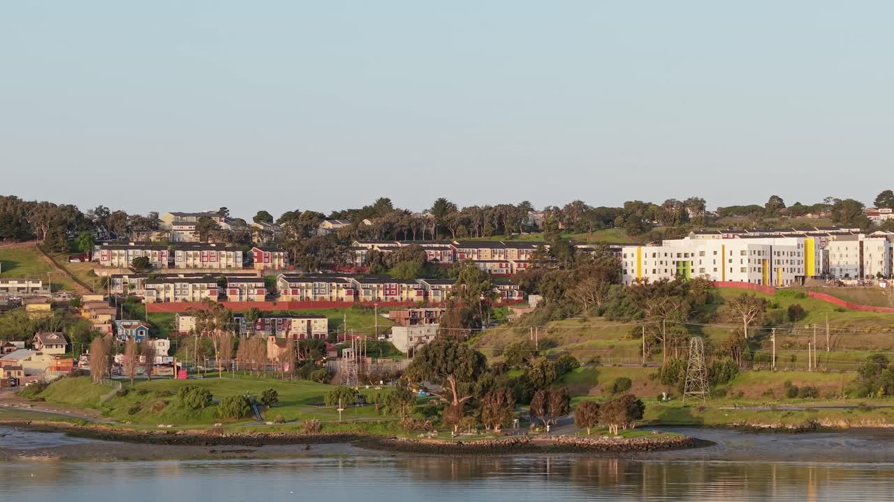 A real time aerial view of the surroundings of Heron's Head Park during sunrise.