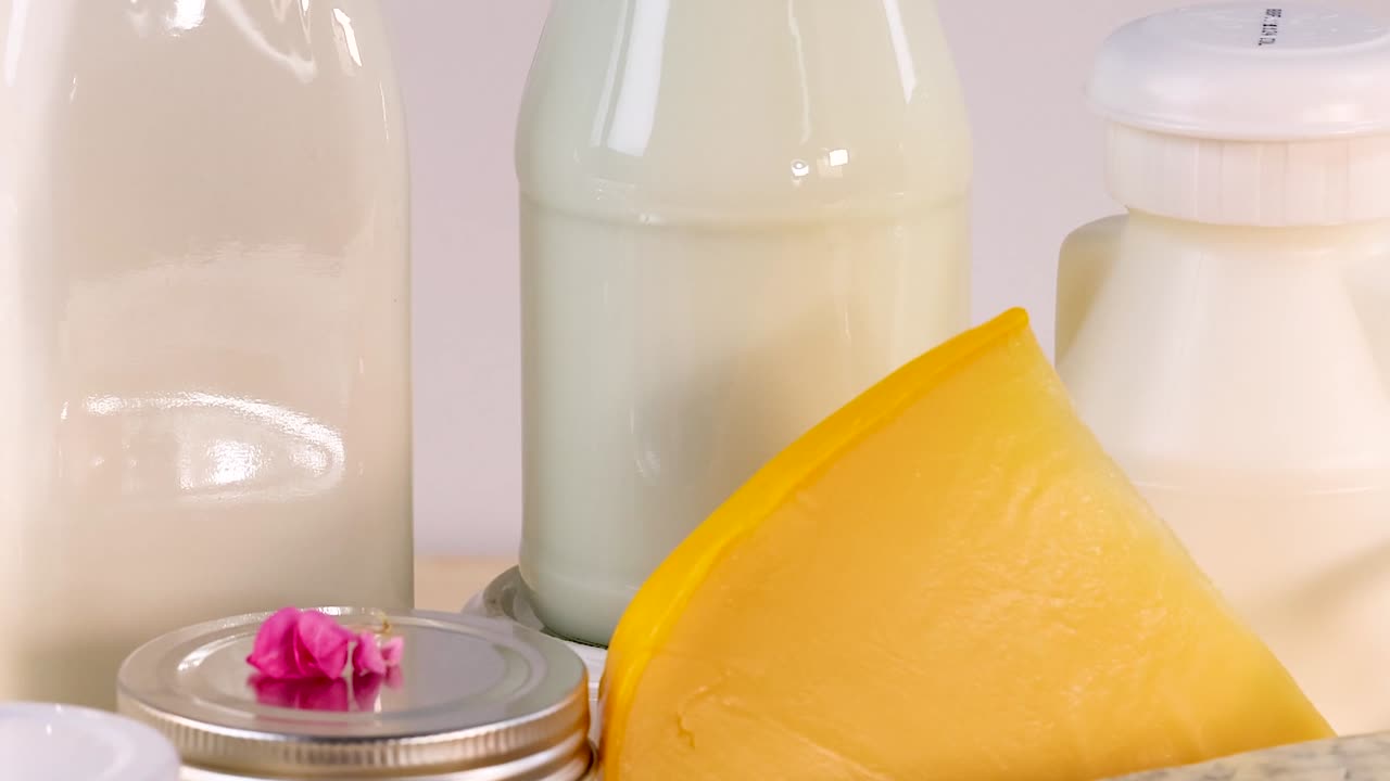 Close-up view of assorted cheeses and dairy products, including milk bottles and butter slices.