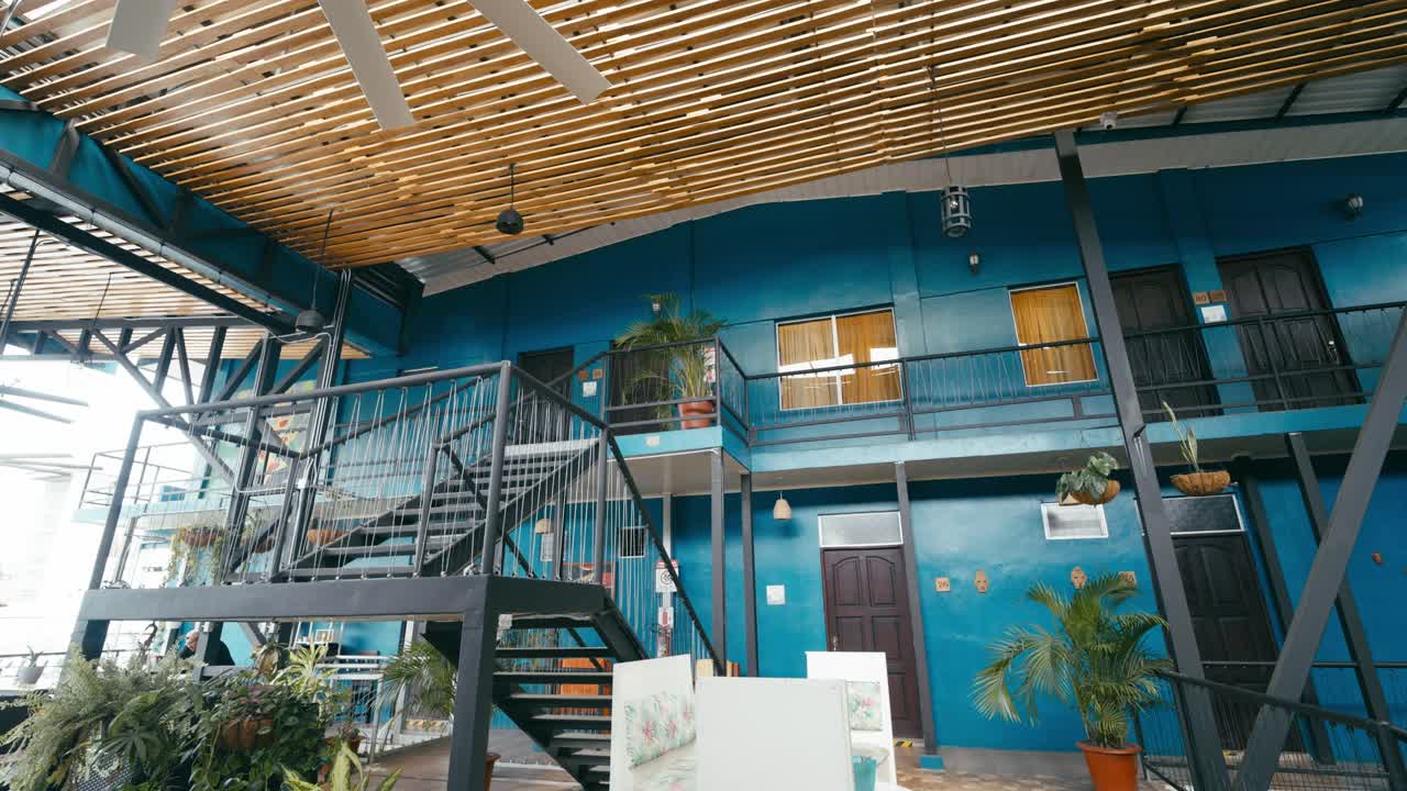 Interior de um edifício com escadas, plantas e varandas