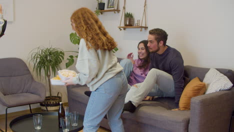 friends preparing food to watch sports game on tv at home