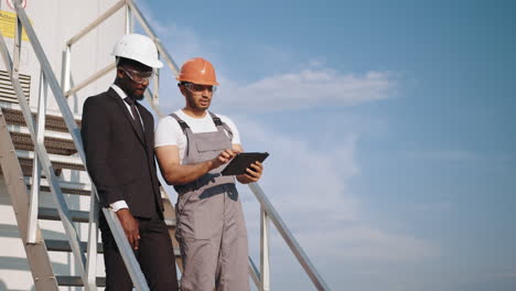 construction workers inspecting a wind turbine