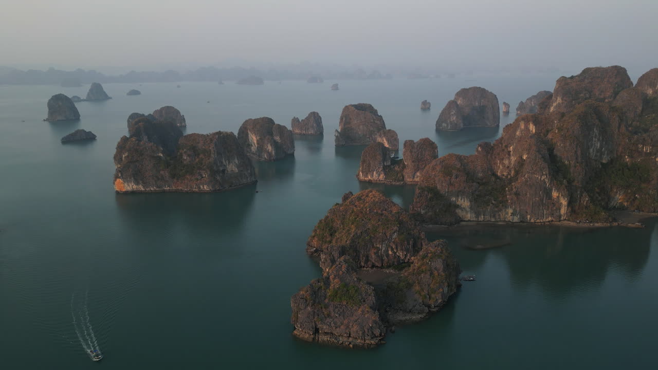 Aerial 4K drone footage over Ha Long Bay, Vietnam, highlighting dramatic limestone islands and scenic emerald waters