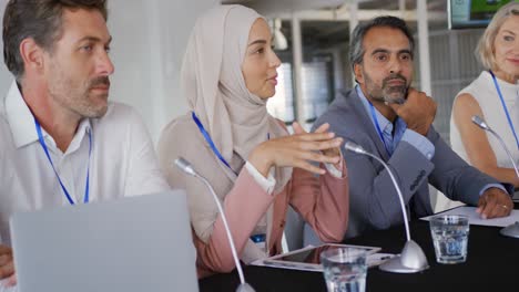 a panel of business delegates talking at a conference