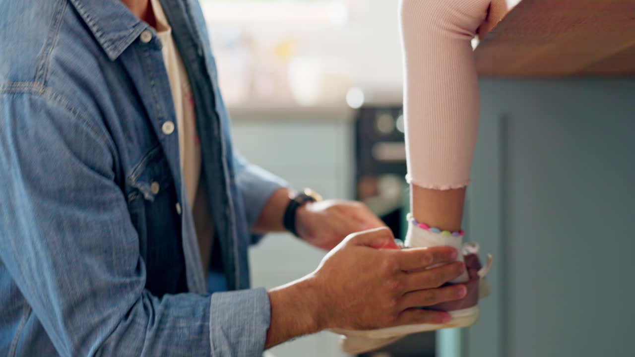 primer plano de un padre atando zapatos a su hijo