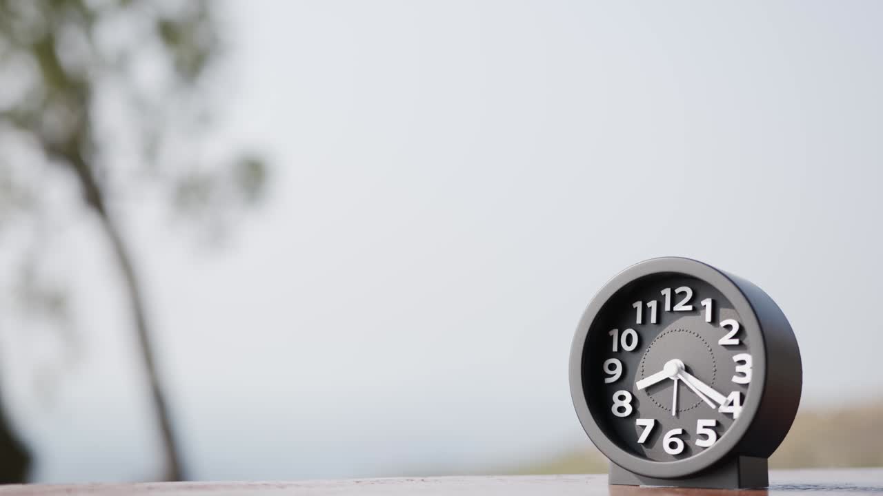 타임 스: 검은 알람 시계는 시간의 흐름을 보여줍니다.